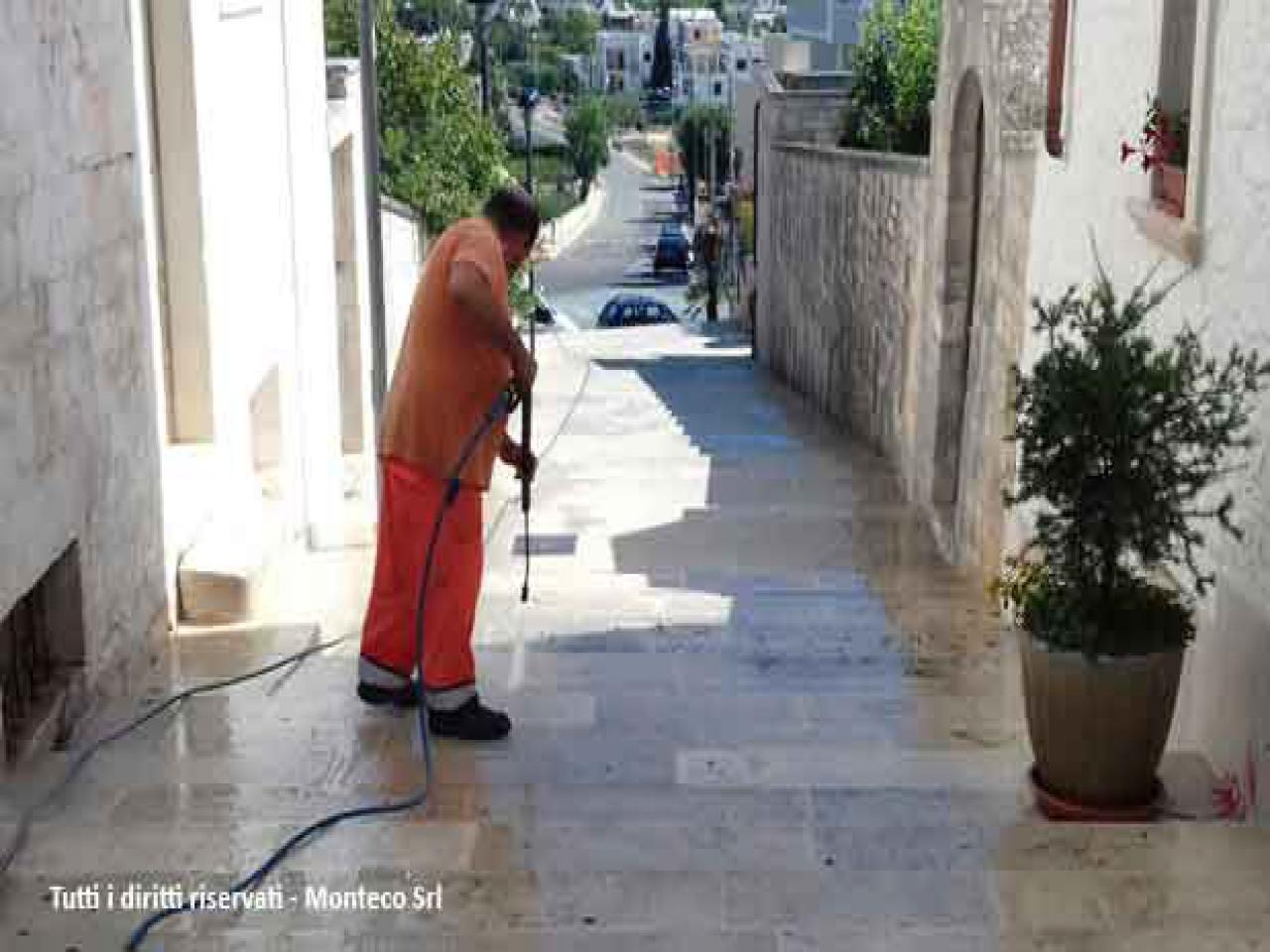 uomo che pulisce strada con idropulitrice