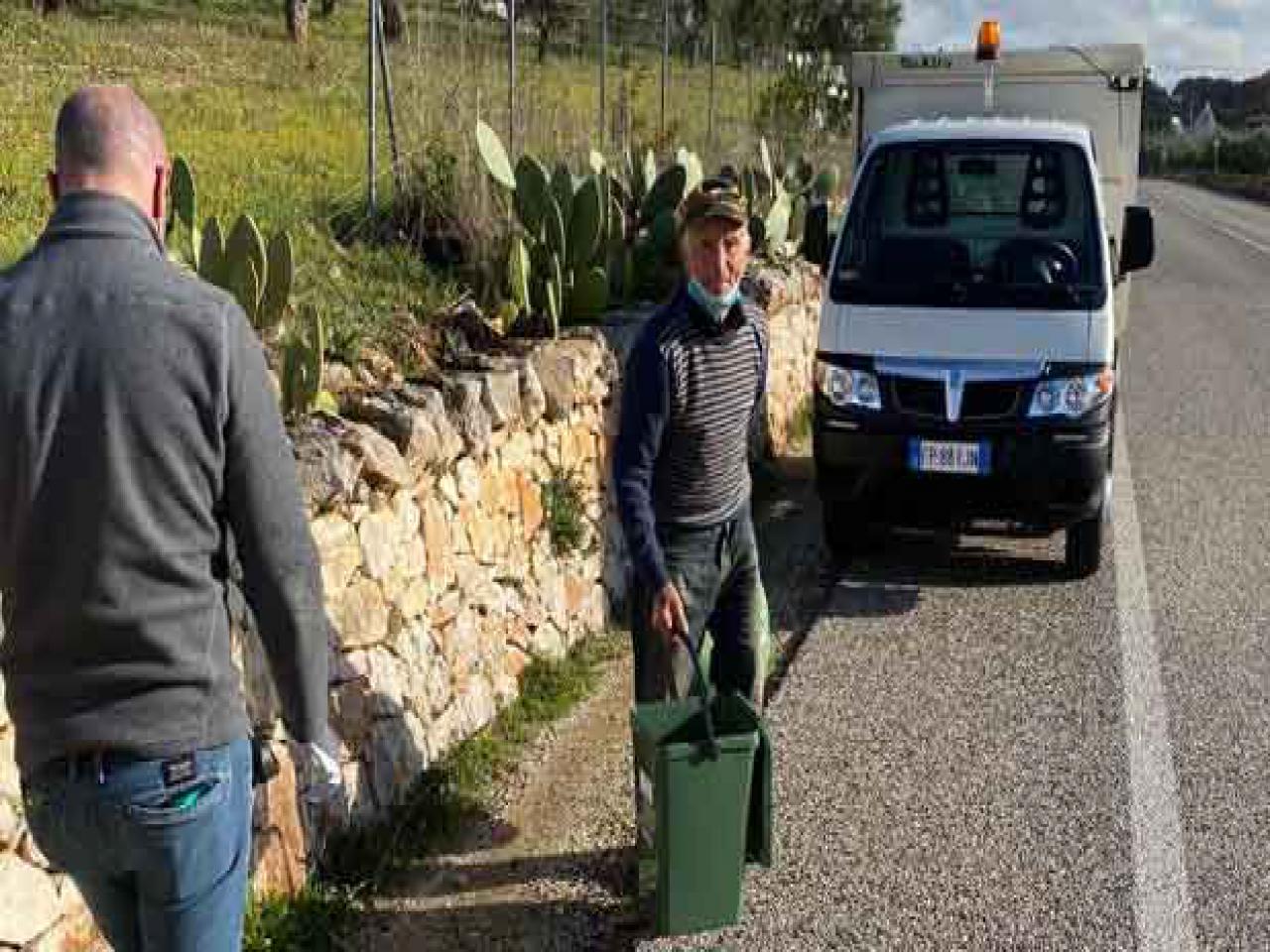 uomo con bidoncino per raccolta rifiuti